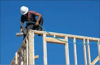  ?? DAVID PAUL MORRIS / BLOOMBERG ?? A contractor works on a KB Home being built at the Vicino community in San Jose, Calif., last week. In addition to supply costs, homebuilde­rs expect to be affected by labor shortages.