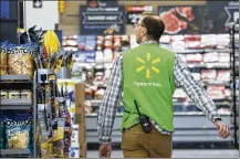  ?? MARK LENNIHAN / AP FILE ?? In this April photo, a Walmart associate works at a Walmart Neighborho­od Market in Levittown, N.Y. Walmart Inc. reported financial results Thursday.