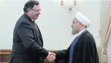  ?? IRANIAN PRESIDENCY OFFICE VIA AP ?? Total SA CEO Patrick Pouyanne shakes hands with Iranian President Hassan Rouhani on Monday in Tehran.