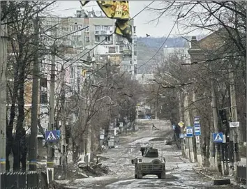  ?? Photograph­s by Libkos ?? UKRAINIAN soldiers ride in a Humvee in Bakhmut in December. In summer, Russia poured soldiers and equipment into capturing the city in the eastern province of Donetsk, and Ukraine did the same to defend it.