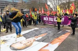  ?? Christine Olsson TT News Agency ?? A PROTESTER in Stockholm jumps toward an image of Turkish President Recep Tayyip Erdogan. Pro-Kurdish groups have been demonstrat­ing in Sweden.