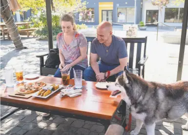  ?? Photos by Sarahbeth Maney / Special to The Chronicle ?? Jessica McGuire ( left), Peter Manning and their dog, Kayla, eat lunch at Plank in Oakland on Friday.