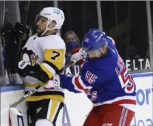  ?? Associated Press ?? New York’s Ryan Lindgren drives Colton Sceviour into the boards in the first period.