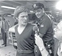  ??  ?? GROUNDED Petit and a police officer after the World Trade Center walk, 1974
