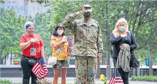  ??  ?? POIGNANT: US Army Sgt Edwin Morales salutes after placing flowers for fallen FDNY firefighte­r Ruben D Correa at a memorial in New York