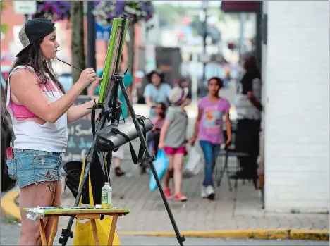  ?? SARAH GORDON/THE DAY ?? Artist Katie Fogg works on painting an urban scene as she stands on State Street on Friday in downtown New London. Fogg plans to spend a month capturing downtown scenes to be shown during her exhibit at Dev’s American Bistro that opens on Sept. 8.