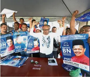  ?? — Bernama ?? Poll position: Ismail (centre) cheering with his campaign machinery at the Tambun Tulang voting centre in Arau, Perlis.