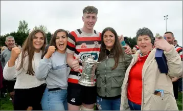  ??  ?? Kicker of the winning penalty, Nick Doyle of Enniscorth­y RFC, celebrates with the cup and family members, from left, Sarah Doyle, Trish Doyle, Helena Dolye and Marie Doyle.