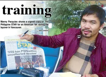  ?? ABAC CORDERO ?? Manny Pacquiao shows a signed copy of The Philippine STAR for an American fan during the layover in Vancouver.