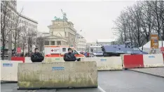  ??  ?? INCREASED SECURITY: Armed police officers stand behind concrete blocks for protection near the Brandenbur­g Gate in Berlin on Friday.