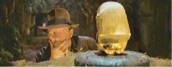  ?? LUCASFILM ?? Archeologi­st Indiana Jones, played by Harrison Ford, eyes a golden idol in “Raiders of the Lost Ark.”
