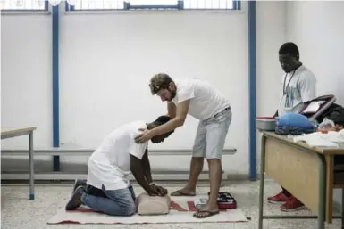  ?? VALENTINO BELLINI/THE WASHINGTON POST ?? Instructor Marco Miceli helps Hubert, a migrant from the Ivory Coast, during a first-aid class in Messina.