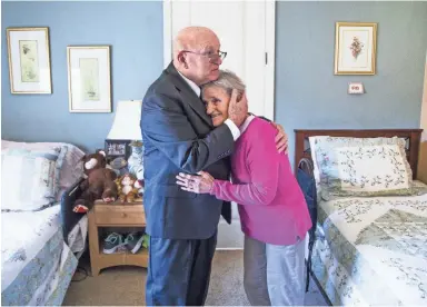  ?? TOM TINGLE/THE REPUBLIC ?? Bob McGuire visits his wife, Linda, in her room at an adult-care home in Goodyear. McGuire is fighting the legal costs he's had to pay as he tries to tap his wife's IRA to help pay for medical expenses after she was diagnosed with dementia.