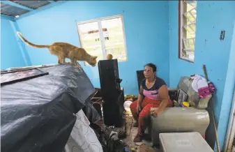  ?? Gerald Herbert / Associated Press ?? Maribel Valentin Espino sits in her storm-destroyed home in Montebello, Puerto Rico, six days after Hurricane Maria slammed the island, creating shortages of food, water and fuel.