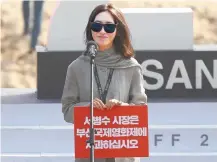 ?? Yonhap ?? Director Pang Eun-jin holds up a picket sign that reads, “Apologize, Mayor Suh” at a BIFF event for her movie, “Method.”