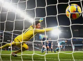  ??  ?? Beaten: Tottenham Hotspur goalkeeper Hugo Lloris fails to stop a shot by Manchester City’s Ilkay Gundogan in the English Premier League match at the Etihad on Saturday. City won 4-1. Below: City goalkeeper Ederson beats Tottenham’s Dele Alli to the ball. — Reuters / AFP