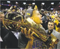  ?? Scott Strazzante / The Chronicle 2015 ?? The Warriors’ Stephen Curry carries the Larry O’Brien Trophy off the court after beating the Cavaliers in Game 6.