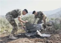  ??  ?? 0 Lebanese soldiers inspect debris from a ground-to-air missile