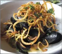  ?? Arkansas Democrat-Gazette/ERIC E. HARRISON ?? A dozen steamed mussels at Ciao Baci come in a parsley-garlic broth, topped with crisp-fried potato strings.