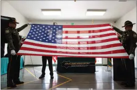  ?? ?? Butte County Sheriff’s Office deputies stretch a flag in preparatio­n of its folding Friday during a memorial service at the Butte County Sheriff’s Office in Oroville.