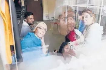 ?? CZAREK SOKOLOWSKI/AP ?? Boshra al-Moallem, bottom left, looks out of the window last Wednesday as she sits in a room with her two sisters and brotherin-law at a refugee center in Bialystok, Poland.
