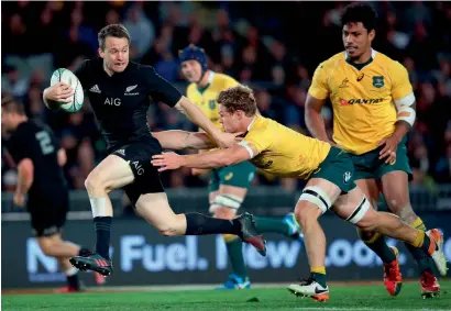  ?? — AFP ?? New Zealand’s Ben Smith (left) breaks a tackle from Australia’s Michael Hooper during the third rugby Bledisloe Cup Test at Eden Park in Auckland on Saturday.