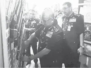  ??  ?? RAMLI (kanan) dan Ketua Polis Daerah Tawau ACP Fadil Marsus (kiri) menemani Ketua Polis Negara Tan Sri Fuzi Harun mengunjung­i pameran barang-barang rampasan dalam Ops Tanduo.