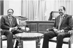  ??  ?? Mohamed (left) pose for a photograph with the outgoing president Hassan Sheikh Mohamud during the hand-over ceremony inside the Presidenti­al palace in Somalia’s capital Mogadishu. — Reuters photo