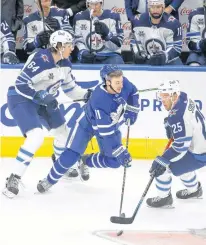  ?? POSTMEDIA NEWS ?? Winnipeg Jets defenceman Logan Stanley (left) checks Maple Leafs forward Zach Hyman during the first period in Toronto on Monday night. Stanley was making his NHL debut.