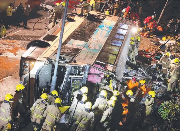  ?? Picture: AFP ?? HORRIFIC SCENE: Firefighte­rs and emergency personnel work to rescue survivors after a double-decker bus toppled in Hong Kong.