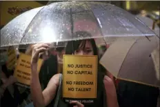  ?? ELSON LI/HK01 VIA AP ?? A woman holds an umbrella and a placard as people gather at Chater Garden to give support to the recent protests against the extraditio­n bill, at the financial district in Hong Kong, Thursday. The Chinese army has released a promotiona­l video for its Hong Kong-based troops at a time of uncertaint­y over whether the military will intervene in the city’s summer of protest.