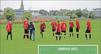  ??  ?? Coach Alan Murray talks to the Arran players prior to a warm-up before the game.