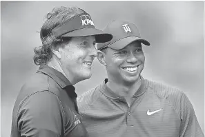  ?? SAM GREENWOOD/GETTY IMAGES ?? Phil Mickelson, left, and Tiger Woods will play a pay-per-view exhibition on Thanksgivi­ng weekend.