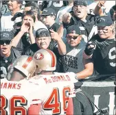  ?? STAFF ARCHIVES ?? Raiders fans in the “Black Hole” harass San Francisco 49ers Merton Hanks and Tim McDonald before a 1999 game in Oakland.