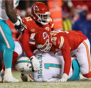  ?? Jamie Squire/Getty Images ?? Kansas City’s George Karlaftis sacks Miami’s Tua Tagovailoa Saturday night in a bitterly cold AFC wild-card game in Kansas City, Mo.