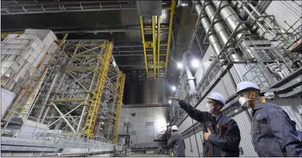  ??  ?? In this June 1 file photo, French Foreign Minister Jean-Yves Le Drian (right) listens to an employee inside the New Safe Confinemen­t (NSC) movable enclosure at the nuclear power plant in Chernobyl, Ukraine. SergeI SuPInSky/Pool PhoTo VIa aP