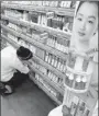  ?? SHEN JINGWEI / FOR CHINA DAILY ?? A saleswoman sorts out a display of Inoherb products at a supermarke­t in Shanghai.
