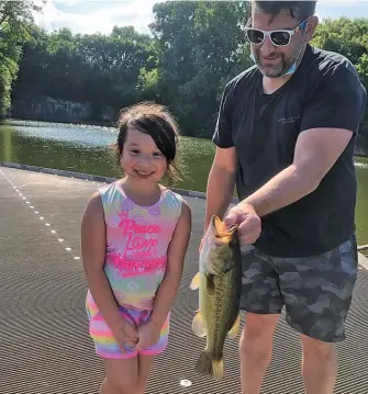  ?? PROVIDED ?? Valeria Vazquez (above) holds a largemouth bass that, with help from David Czuprynski, she caught on an ice rod at Palmisano Park. A.J. Koenigskne­cht (left) hoists the largemouth bass he caught last weekend on a family excursion.