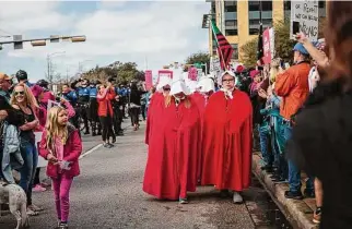  ?? Contributo­r file photo ?? Women dressed as characters from “The Handmaid’s Tale” march for women’s rights in January 2018 on their way to the capitol in Austin.