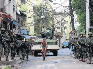  ?? WILTON JUNIOR/ESTADÃO–7/2/2018 ?? Cenas cariocas.
Ao longo de anos, moradores do Rio de Janeiro convivem em meio a soldados em bairros como a Cidade de Deus (no alto, neste ano) e o Complexo do Alemão (ao lado); abaixo, ação na Vila Cruzeiro e soldado assiste a uma partida de futebol