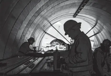  ?? Photos by Brett Coomer / Staff photograph­er ?? Workers put together lighting inside a tunnel Wednesday at Memorial Park. Work on the concrete tunnel began in late 2020.