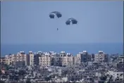  ?? ARIEL SCHALIT — THE ASSOCIATED PRESS ?? Parachutes are used to drop humanitari­an aid over the northern Gaza Strip, as seen from southern Israel, Tuesday.