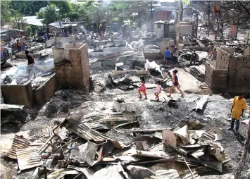  ??  ?? Fire victims in Lawaan III, Talisay City look for something to salvage after their houses were razed by fire on Christmas Eve.