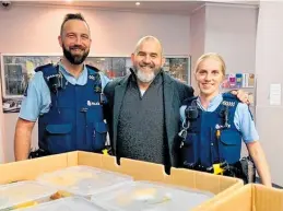  ??  ?? Taupo¯ police officers Courtney Robertson (left) and Sheryl Mansell (right) receive the home made dinners from Sean Wakelin (centre).