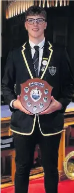 ??  ?? Hard-working Calvin Quigley with his Livingston award, recognisin­g his contributi­on to the school and its wider community