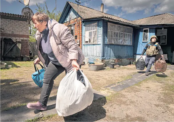  ?? ?? Residents including Olena, right, are evacuated from Vovchansk, north-east Ukraine