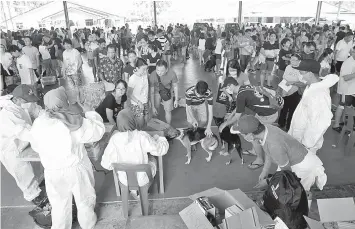  ?? - Bernama photo ?? Members of the public bringing their dogs for vaccinatio­n by the Veterinary Services Department at the Jalan Arang basketball court in Batu Kawa, Kuching yesterday.