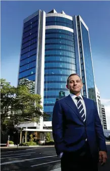  ?? PHIL BARTSCH Photo: Megan Slade/AAP ?? TOWERING FEAT: Adam Barrett at 310 Ann St, Brisbane CBD, where two big office leases have been signed.