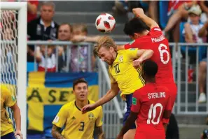  ?? Associated Press ?? ■ England's Harry Maguire, right above, scores his side's opening goal during the quarterfin­al match between Sweden and England at the 2018 World Cup in the Samara Arena on Saturday in Samara, Russia.