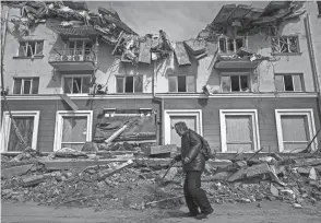  ?? EVGENIY MALOLETKA/AP ?? A man walks past an apartment building damaged by shelling in Chernihiv, Ukraine, on Thursday. Ukraine is telling residents of its industrial heartland to leave while they still can after Russian forces withdrew from the shattered outskirts of Kyiv to regroup for an offensive in the country’s east.